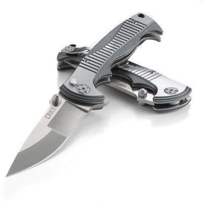 Nóż Składany CRKT 5290 Tighe Rade Nóż CRKT ze składanym ostrzem (folder) wyposażony jest w gładkie ostrze Drop Point. Ten typ ostrza ma bardzo dobre właściwości tnące oraz wytrzymały czubek. Drop Point jest szczególnie przydatny w nożach myśliwskich i roboczych ogólnego przeznaczenia. Ostrze wykonano ze stali nierdzewnej 8Cr13MoV. Ma twardość 58-60 HRC. Rękojeść posiada okładziny - LifeGun.pl Nóż składany CRKT 5290 Tighe Rade-6